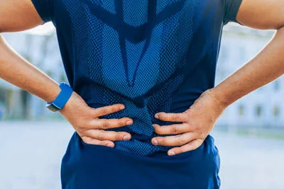 Person holding their lower back